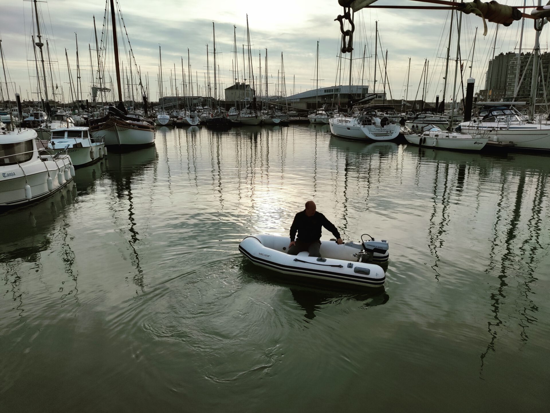 Frank fährt mit dem Beiboot  durchs Hafenbecken